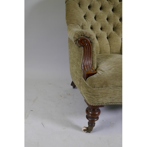 1105 - A Victorian walnut easy chair with button back and scroll arms, raised on turned supports with brass... 