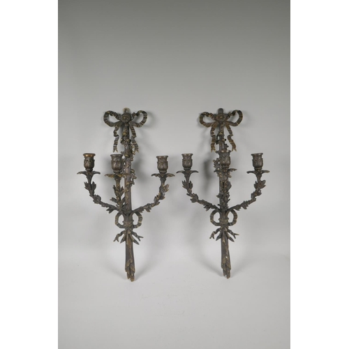 119 - A pair of bronze Rococo style branch candle sconces with ribbon and leaf decoration, 54cm