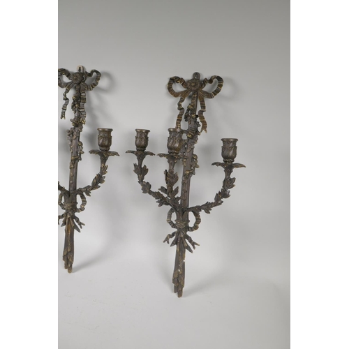 119 - A pair of bronze Rococo style branch candle sconces with ribbon and leaf decoration, 54cm