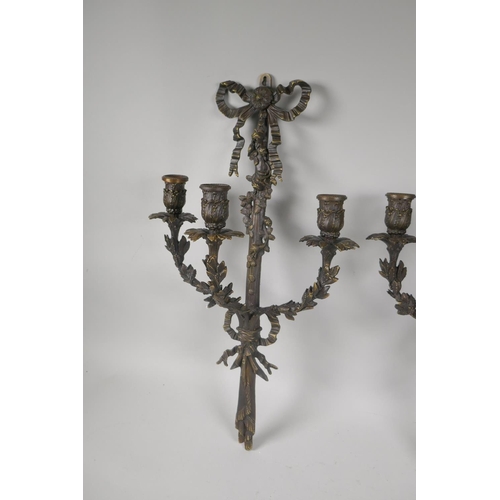 119 - A pair of bronze Rococo style branch candle sconces with ribbon and leaf decoration, 54cm