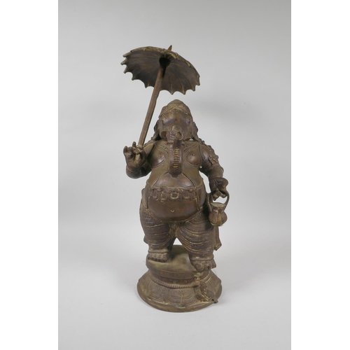 12 - An antique Indian bronze figure of Ganesh carrying a parasol, 41cm high