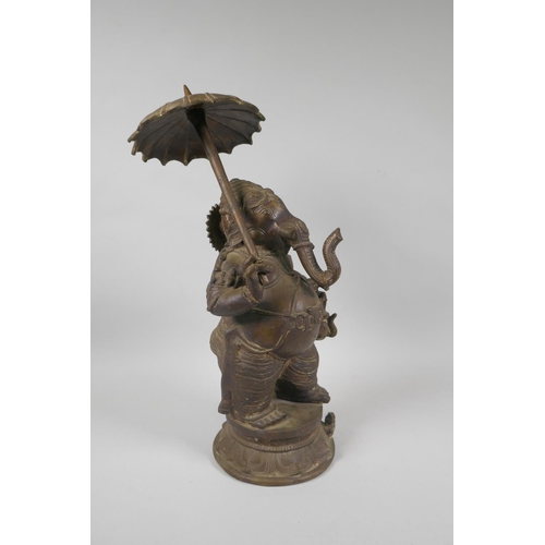 12 - An antique Indian bronze figure of Ganesh carrying a parasol, 41cm high