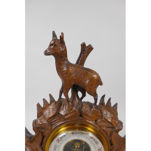 120 - A brass barometer in a carved Black Forest mount, decorated with a deer and leaves, 29cm high