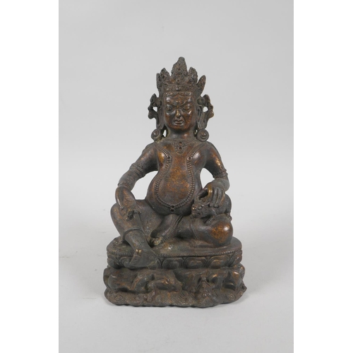 121 - A Tibetan bronzed metal figure of Jambhala, with the remnants of gilt patina, 18cm high