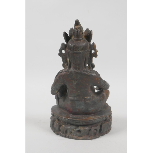 121 - A Tibetan bronzed metal figure of Jambhala, with the remnants of gilt patina, 18cm high