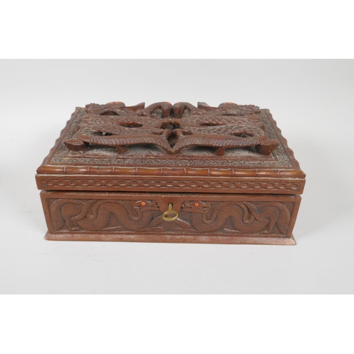 129 - An antique Burmese carved camphor wood jewellery box with entwined dragon decoration, and another sm... 