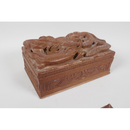 129 - An antique Burmese carved camphor wood jewellery box with entwined dragon decoration, and another sm... 