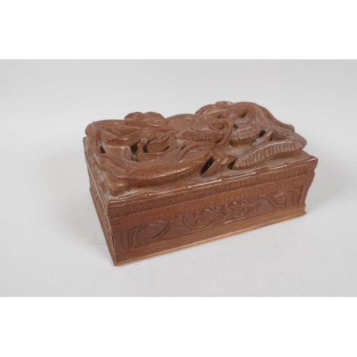 129 - An antique Burmese carved camphor wood jewellery box with entwined dragon decoration, and another sm... 