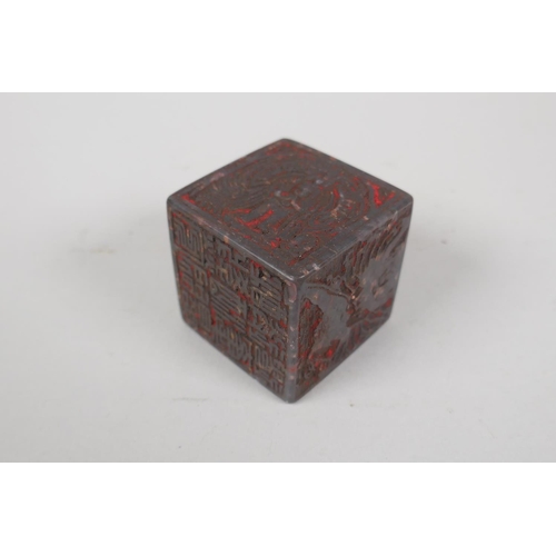 133 - A Chinese carved soapstone cube shaped seal, with images and inscriptions to each face, 5 x 5 x 5cm