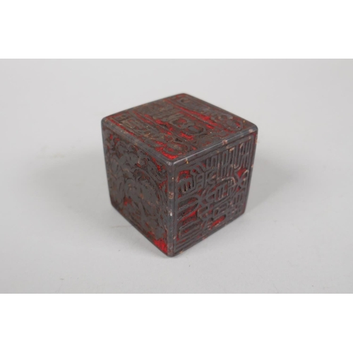 133 - A Chinese carved soapstone cube shaped seal, with images and inscriptions to each face, 5 x 5 x 5cm