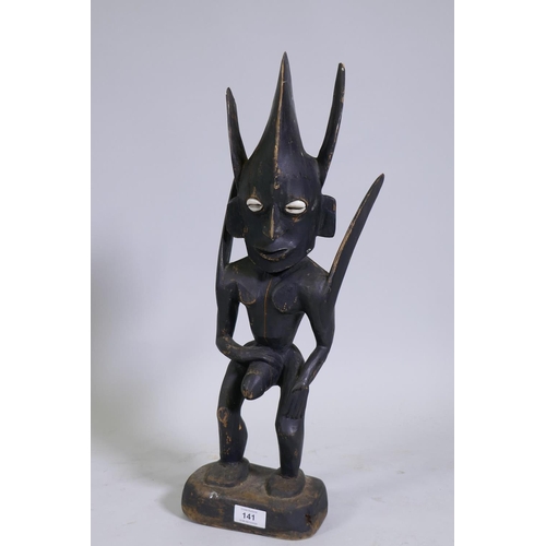 141 - An African tribal carved and ebonised wood fertility figure with shell eyes, 55cm high 