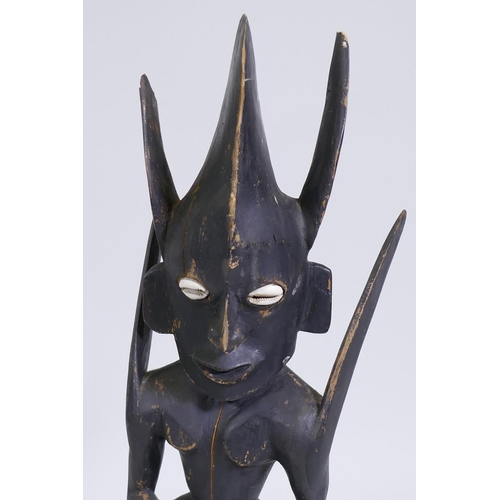 141 - An African tribal carved and ebonised wood fertility figure with shell eyes, 55cm high 