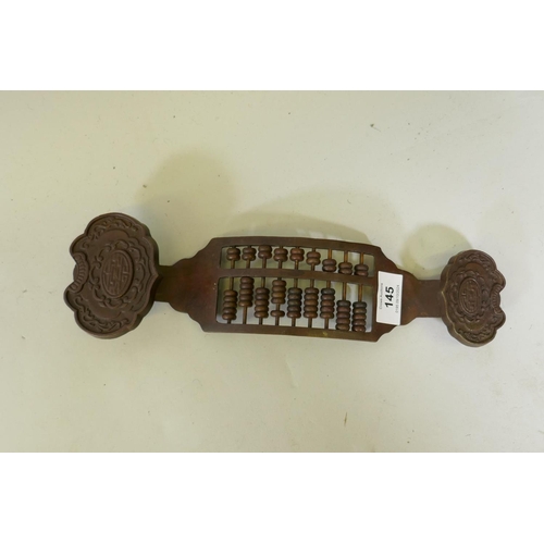 145 - A Chinese bronze abacus in the form of a ruyi, 33cm long