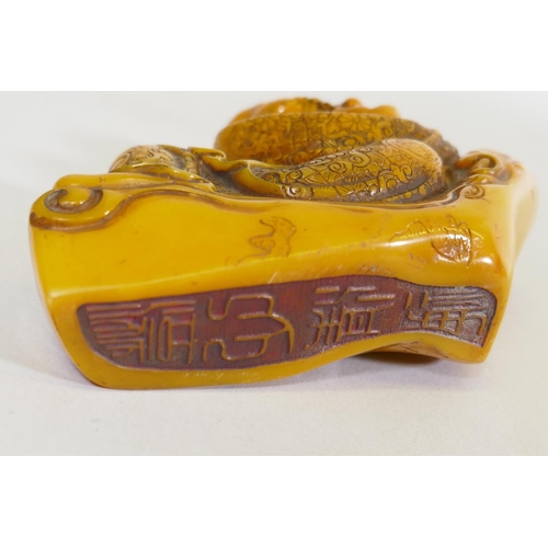 149 - Amber style seal in the form of Lo-han, reclining, 9.5cm high