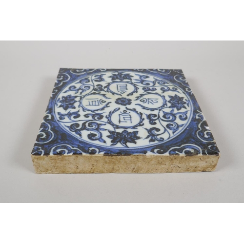 163 - A Chinese blue and white porcelain temple tile, decorated with lotus flowers and character inscripti... 