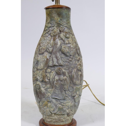 169 - A Chinese bronze table lamp, the body with raised decoration depicting immortals amongst clouds, mou... 