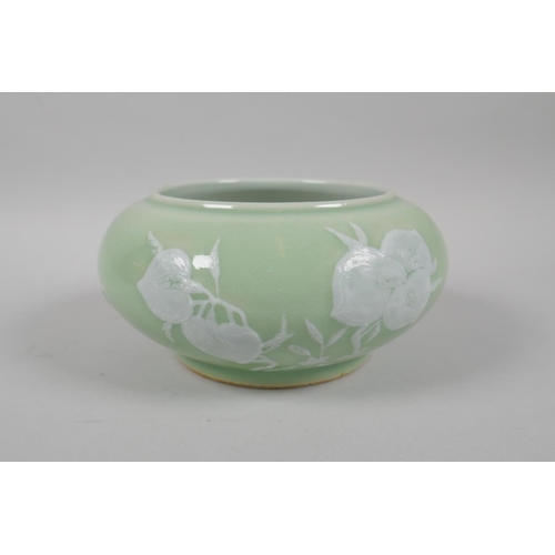 183 - A Chinese celadon glazed porcelain bowl with rolled rim, with raised enamel peach tree and bat decor... 