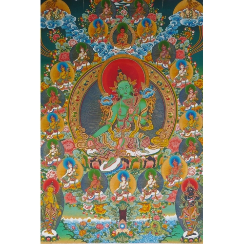 185 - A Tibetan thangka depicting green tara, in a silk hanging mount, 64cm wide