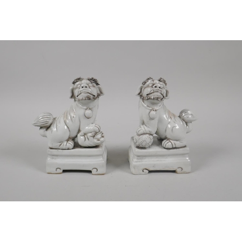 190 - A pair of Chinese blanc de chine porcelain incense stick holders in the form of fo-dogs, 13cm high