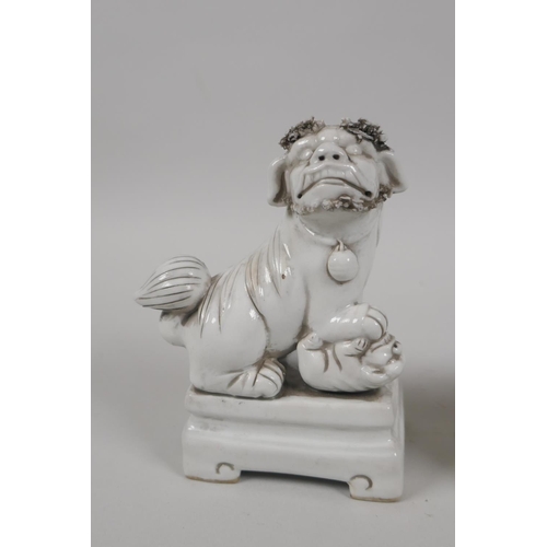 190 - A pair of Chinese blanc de chine porcelain incense stick holders in the form of fo-dogs, 13cm high