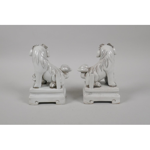 190 - A pair of Chinese blanc de chine porcelain incense stick holders in the form of fo-dogs, 13cm high