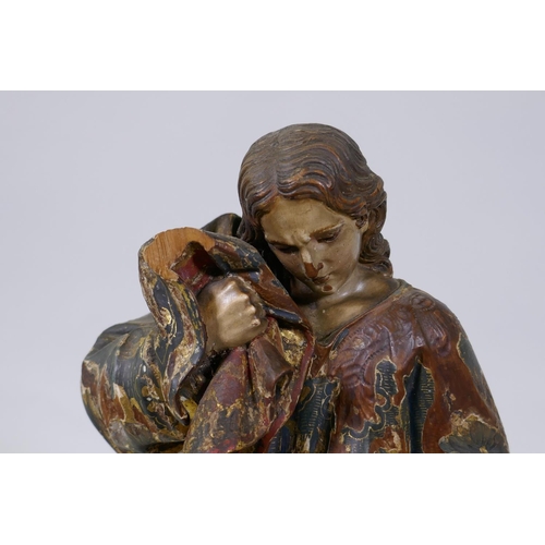 2 - A carved limewood figure of Saint John with polychrome and parcel gilt decoration and glass eyes, pr... 