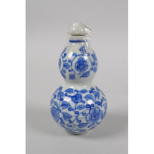 201 - A Chinese blue and white porcelain double gourd snuff bottle with scrolling floral decoration, and a... 