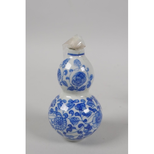 201 - A Chinese blue and white porcelain double gourd snuff bottle with scrolling floral decoration, and a... 