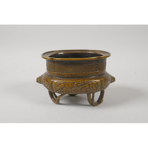 216 - A Chinese bronze censer with two lion mask handles and raised on bamboo feet, 8cm high