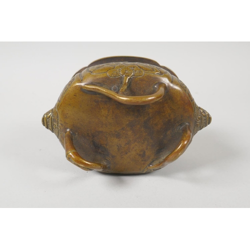 216 - A Chinese bronze censer with two lion mask handles and raised on bamboo feet, 8cm high