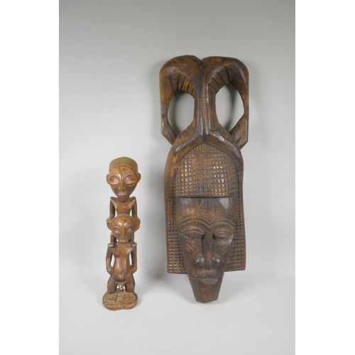 219 - An African carved wood wall mask, and a congolese carved wood figure of a mother and child, largest ... 