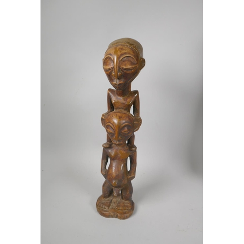 219 - An African carved wood wall mask, and a congolese carved wood figure of a mother and child, largest ... 