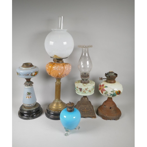 242 - Five C19th and early C20th oil lamps with glass reservoirs and shades, and a quantity of oil lamp ch... 