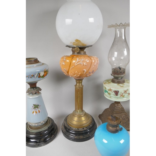 242 - Five C19th and early C20th oil lamps with glass reservoirs and shades, and a quantity of oil lamp ch... 