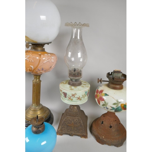 242 - Five C19th and early C20th oil lamps with glass reservoirs and shades, and a quantity of oil lamp ch... 