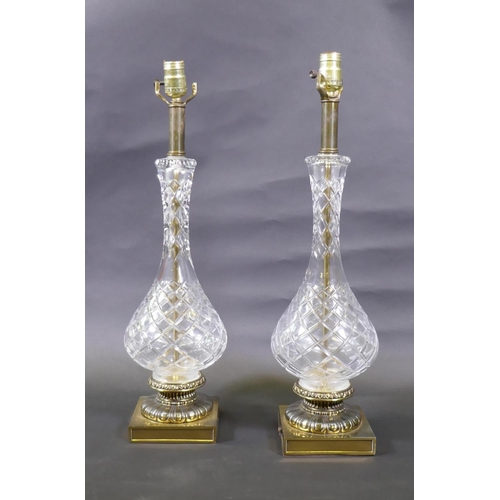 47 - A pair of cut glass table lamps mounted on brass bases, 61cm high