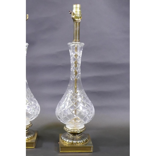 47 - A pair of cut glass table lamps mounted on brass bases, 61cm high