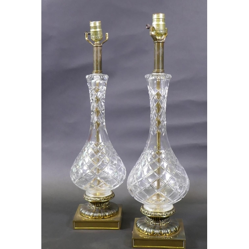 47 - A pair of cut glass table lamps mounted on brass bases, 61cm high