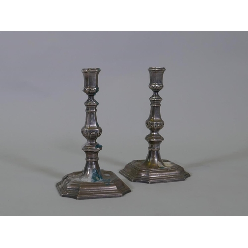 602 - A pair of mid C18th Dutch silver candlesticks, on square form bases with cut corners and moulded tap... 