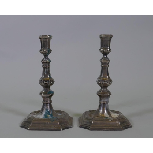 602 - A pair of mid C18th Dutch silver candlesticks, on square form bases with cut corners and moulded tap... 