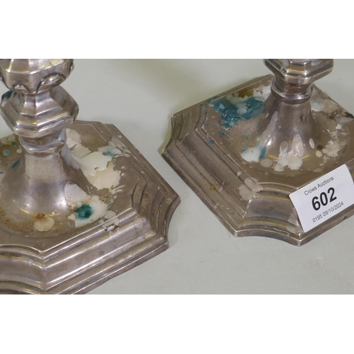 602 - A pair of mid C18th Dutch silver candlesticks, on square form bases with cut corners and moulded tap... 