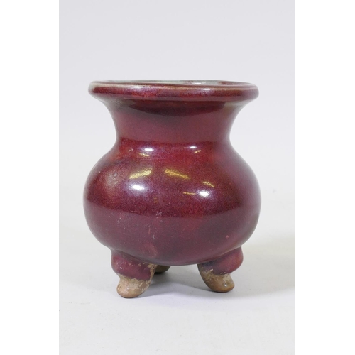 61 - A Chinese sang de boeuf flambe glazed ceramic jar on tripod supports, 16cm high