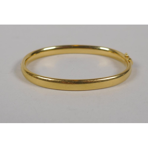 624 - A yellow metal bangle, tests as gold, marked indistinctly but ends '50' (750?), 15.6g