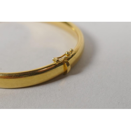 624 - A yellow metal bangle, tests as gold, marked indistinctly but ends '50' (750?), 15.6g