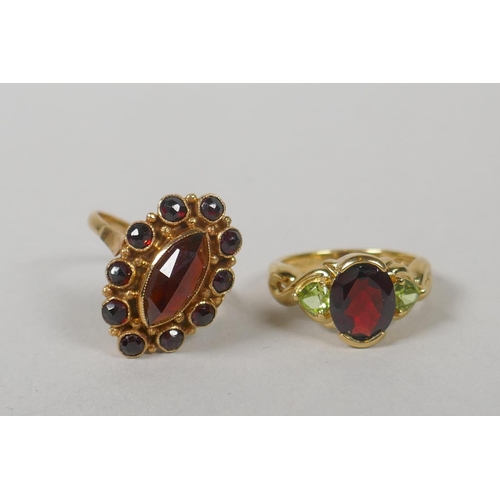 628 - A 14ct gold lady's dress ring set with a large marquise cut garnet encircled by ten smaller, size O,... 