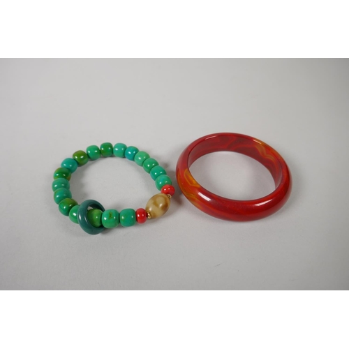 647 - Red agate bangle, 7cm diameter, and a turquoise style beaded bangle