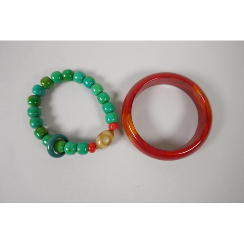 647 - Red agate bangle, 7cm diameter, and a turquoise style beaded bangle