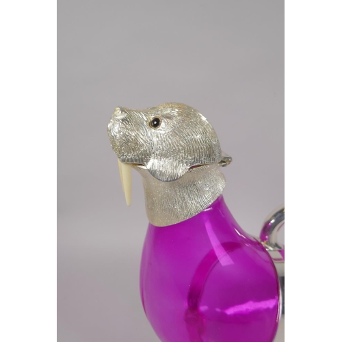 648 - A pink glass and silver plated claret jug in the form of a seal, 34cm long