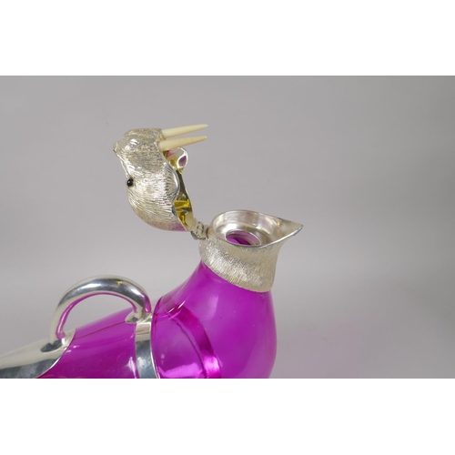 648 - A pink glass and silver plated claret jug in the form of a seal, 34cm long