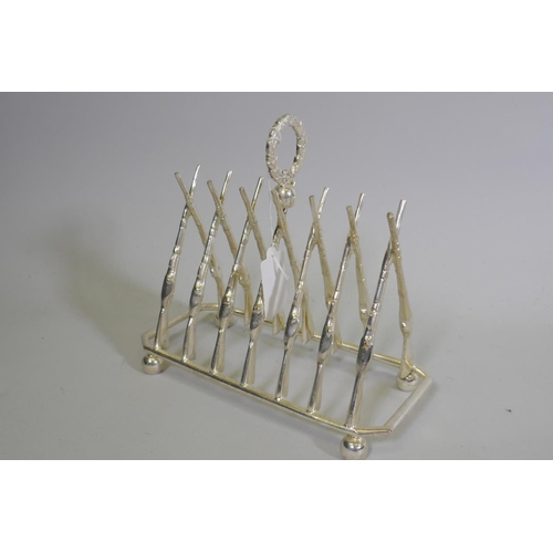 650 - A silver plated letter/toast rack in the form of leaning rifles, 20 x 9 x 18cm